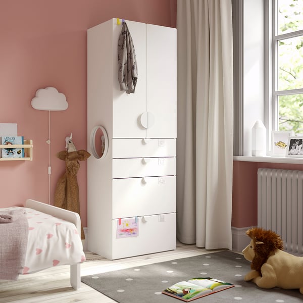 Kids room with white SMÅSTAD wardrobe, safety soft toys, grey rug.