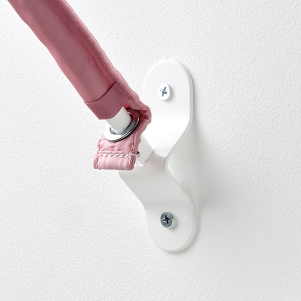 Childs hand reaches up to a securely mounted white wall holder, demonstrating robust design and safety in a minimalist setting.