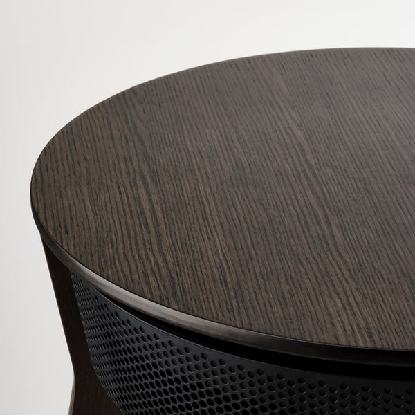 Dark wooden round table top with sleek, perforated black metal edge, showcasing fine craftsmanship and modern design.
