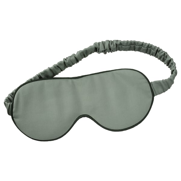 Green STJÄRNANEMON eye mask with black trim and elastic headband.