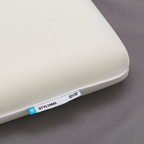 A cool white pillow by IKEA, labelled STYLTMAL, is shown. The soft, ergonomic design is evident.
