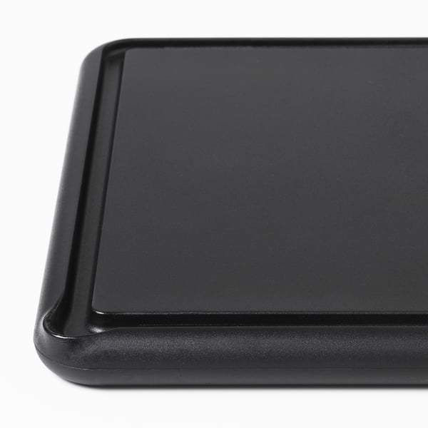 Black chopping board, smooth surface, durable plastic, deep grooves for juice collection.