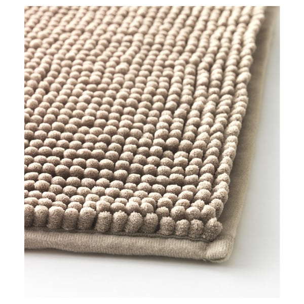 Close-up of textured, beige bath mat with soft nub detail, showcasing its quality and design.
