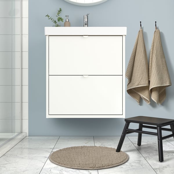 Modern bathroom with a clean white vanity, marble floor, and TOFTBO mat in dark beige. The mats round, plush, and fits perfectly under the stool.