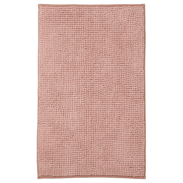 A TOFTBO bath mat in beige. Its rectangular, plush, and made of recycled polyester.