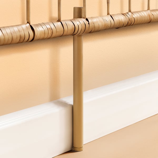 Close-up of a beigebrown rattan headboards detailed, handwoven texture, supported by sturdy gold-colored metal.