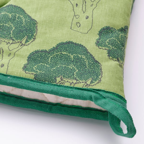 Green oven mitt with dark trim, light green trees, high-quality stitching.