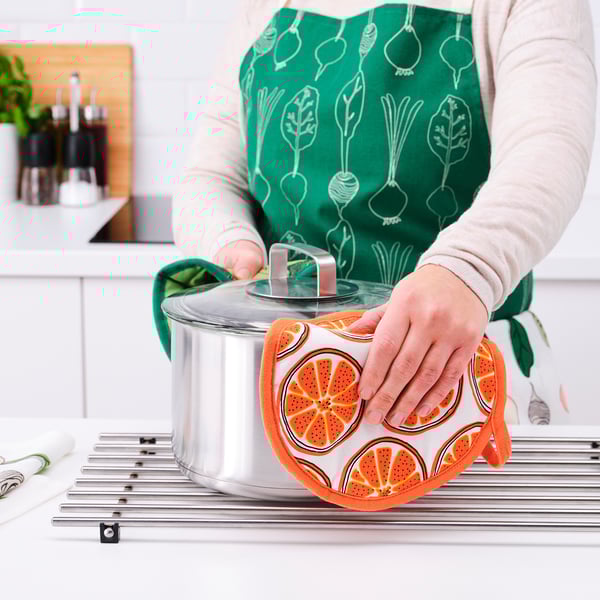 Person cooking on gas stove with pad.