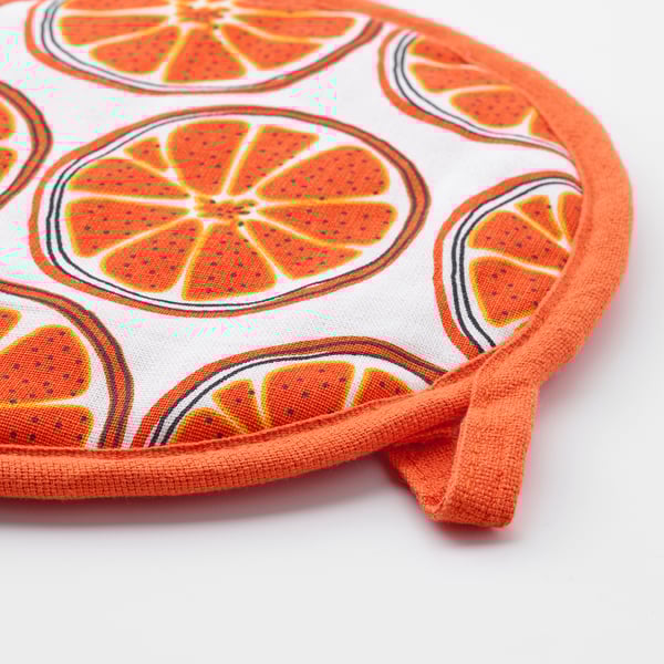 Round potholder with bright orange trim, featuring large orange slices on white fabric, showcasing vibrant citrus design.