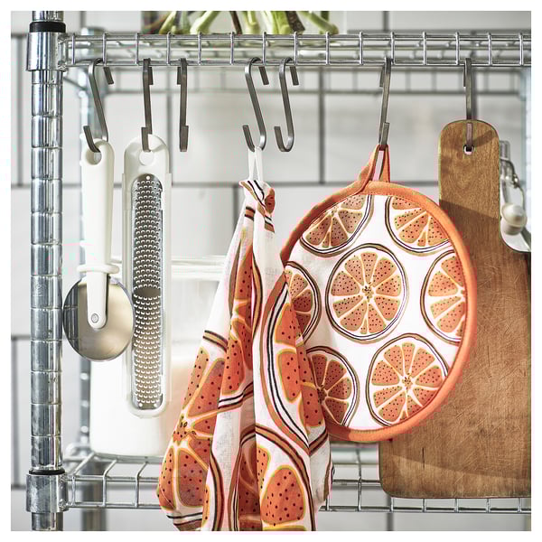 Kitchen hooks with citrus print towel and grater.
