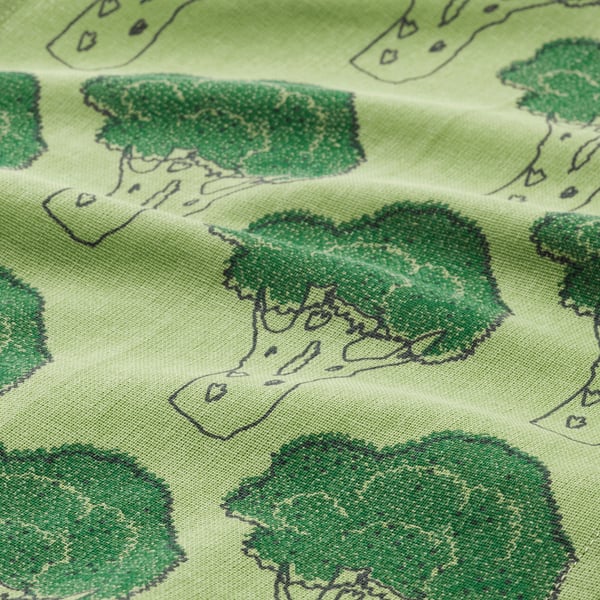 Green patterned fabric with leafy designs, likely made of cotton.