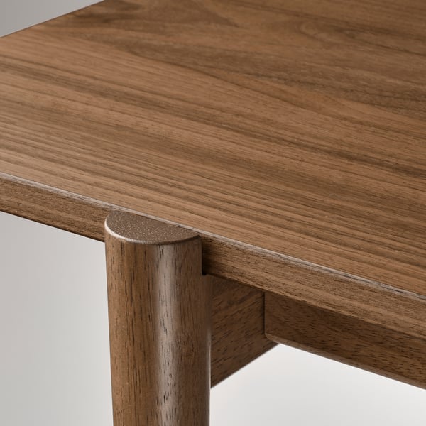 Close-up of sleek, mid-century inspired table with smooth, warm wood grains and polished edges, showcasing craftsmanship and sophisticated design.