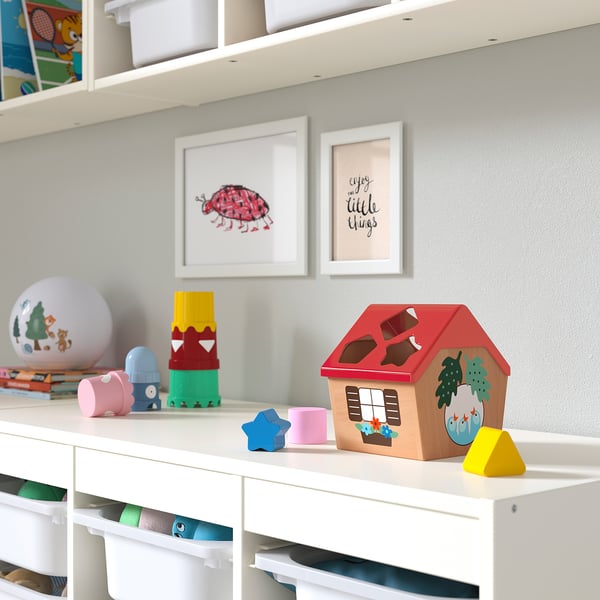 Play area with UPPSTÅ shape sorter, red birdhouse toy, shapes, near blocks and globe, framed pictures.