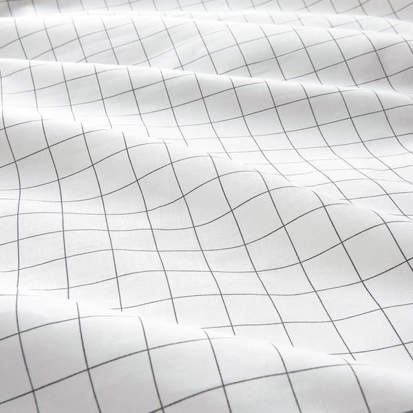 Grid-patterned white duvet cover fabric, neatly stitched, showcasing high-quality cotton texture.