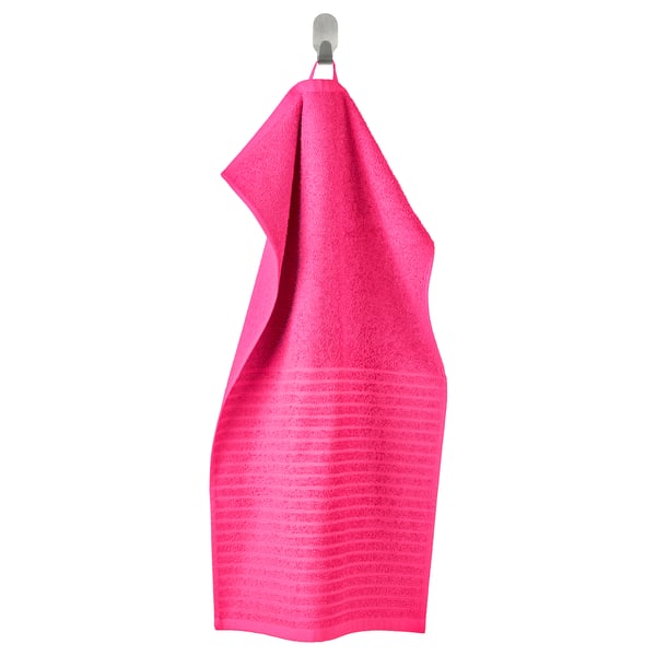 Bright pink VÅGSJÖN towel hangs on silver hook, textured, rectangular.