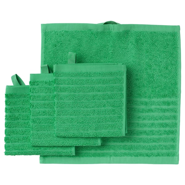 Bright green VÅGSJÖN towels, including bath and hand towels, neatly stacked. Soft, absorbent cotton with a ribbed texture.