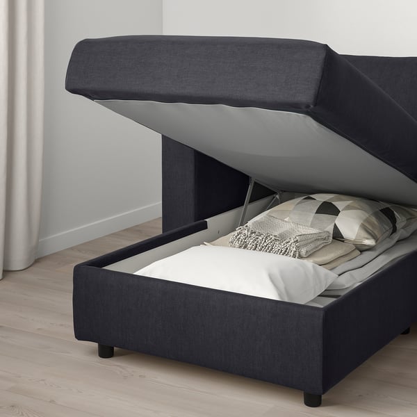 Bed with open storage, white linens, grey upholstery.