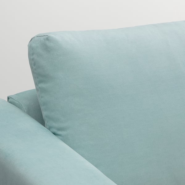 Sofa corner with plush, light blue upholstery, showcasing premium fabric and cushion support.