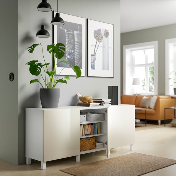 Modern living space with BESTÅ sideboard, displaying books and decor, flanked by pendant lamps and a potted plant.
