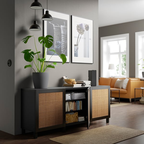 Sideboard with shelves, books, plant, closed cabinet, wall art, lamps.