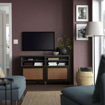 Modern living room with BESTÅ black tv stand, flat screen tv, blue couch, decorative items, and woven basket.