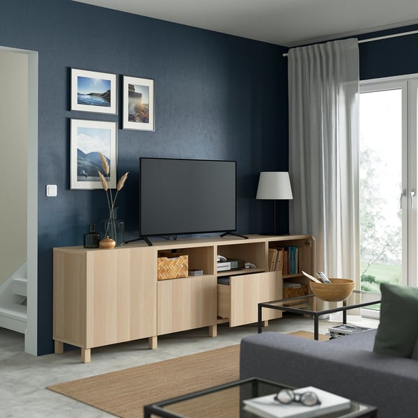 Modern living room with light wood tv stand, flat screen, grey walls, adjustable shelves.