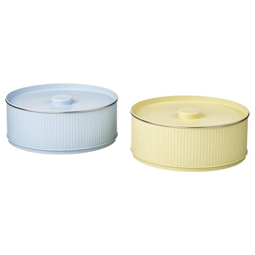 Two round containers, one light blue, one mustard yellow, with ribbed design and plastic lids.