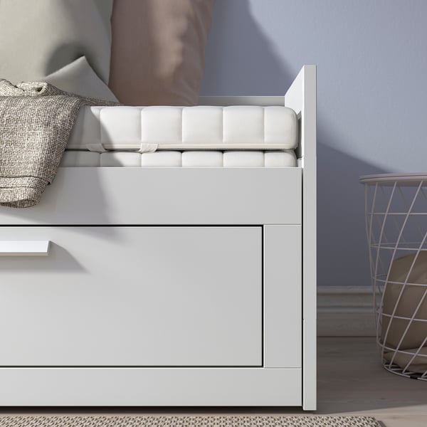 A versatile day-bed with two drawers for storage, transforming into a double bed, shown with a folded mattress.
