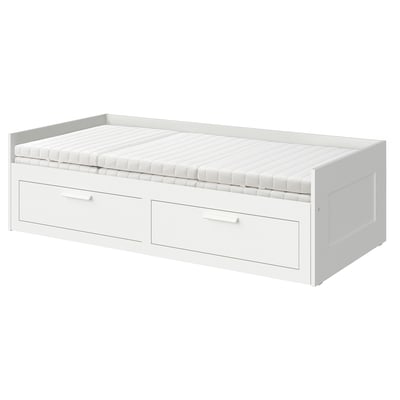 Displays a white BRIMNES day-bed with two drawers, suitable for small spaces. It converts from a sofa to a bed.