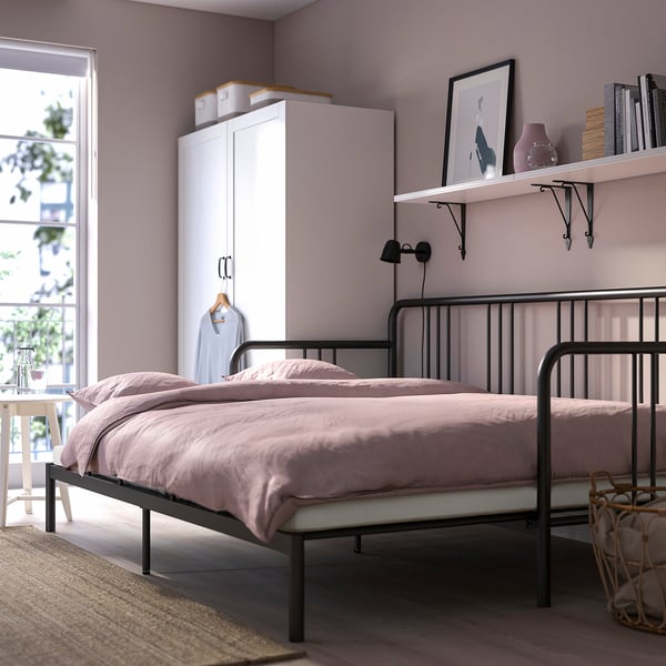 Lavender day-bed with metal frame, coir mattress, shelf above, closet beside.