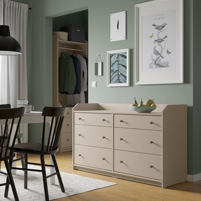 Cream HAUGA chest with 6 drawers, artwork above, silver knobs, bowl of fruit on top.