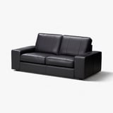 Black KIVIK leather sofa, sleek modern design, low armrests, comfortable cushions.