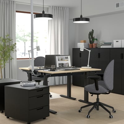 Modern home office with MITTZON sit/stand desk, grey chairs, sleek decor, and multiple monitor setup.