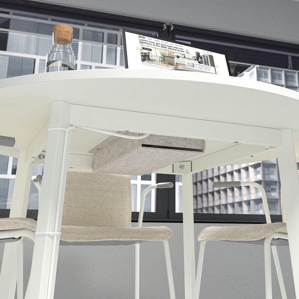 Modern office setup with round table and stools, instructions displayed.
