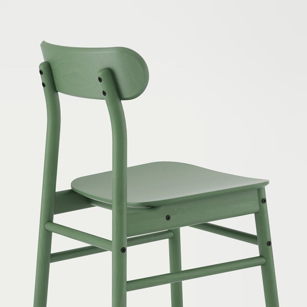 A green chair with curved seat and backrest, made of wood and veneer, set against white background.