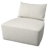 A light beige, cushioned chair with a rectangular pillow. It has a boxy, modern design and is covered in a textured fabric.