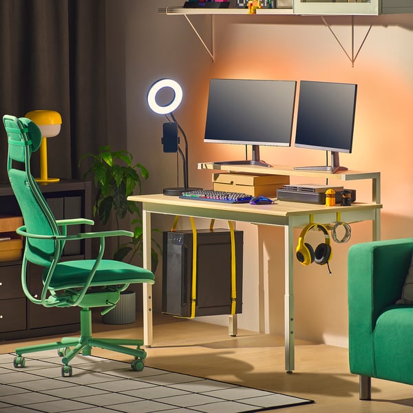 UTVISNING gaming desk with dual monitors, green chair, headphones, and cable management.