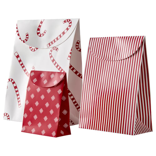 Two festive gift bags: one with red stripes, the other with red snowflakes on white. Brown paper material with string closures.