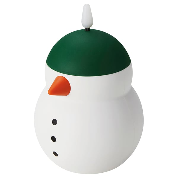 A VINTERFINT decorative snowman lamp. Its white, green, and orange, with a round body and a green hat. It produces a warm, glowing light.