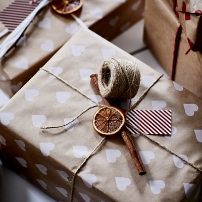 Brown paper gift box with hearts, jute string, cinnamon, dried orange, tag.