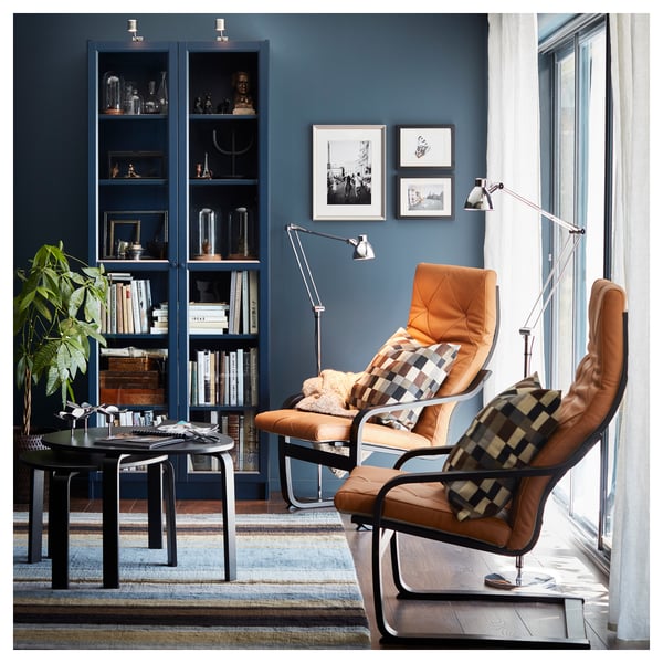 Modern living room with blue walls, leather armchairs, and BILLY blue bookshelf filled with books and decorative items.