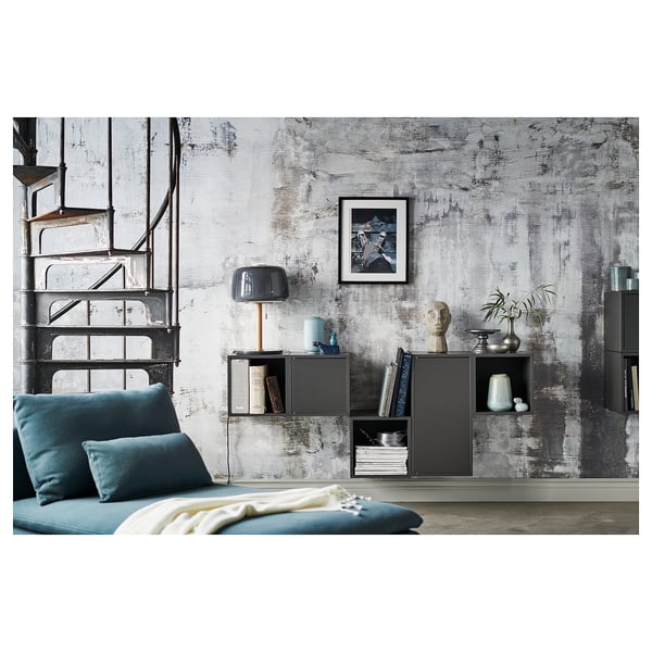 Modern living space with blue accented furniture, rustic wall, metal stairs, and decorative items.