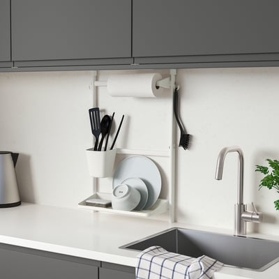 Modern kitchen with wall-mounted SUNNERSTA organizer: small, white, steel, holding dishes, utensils, and paper towels.