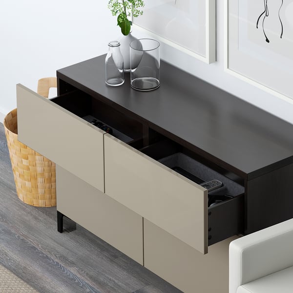 Modern media console with open drawer revealing remote and electronic devices, featuring sleek design and open storage.
