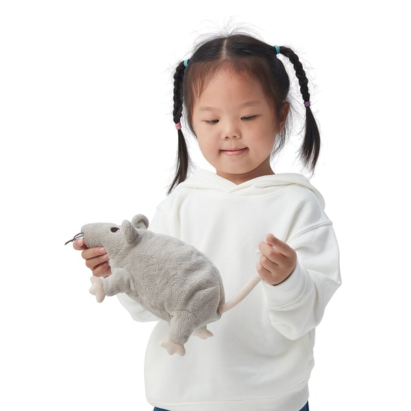 Child holding gray GOSIG RÅTTA plush toy in white hoodie.