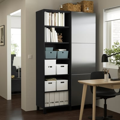Black storage unit with shelves, drawers, desk, and chair in home office corner.
