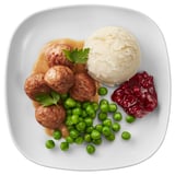 Assiette carrée avec des boulettes de viande, de la purée de pommes de terre, des petits pois et de la confiture.