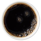 Cup of black coffee with foam.