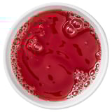 Top view of a bowl with dark red liquid, likely beverage; simple and vibrant.