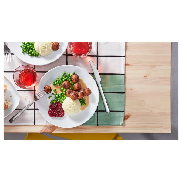Vervallen dineropstelling met borden, bestek en glazen op houten tafel.